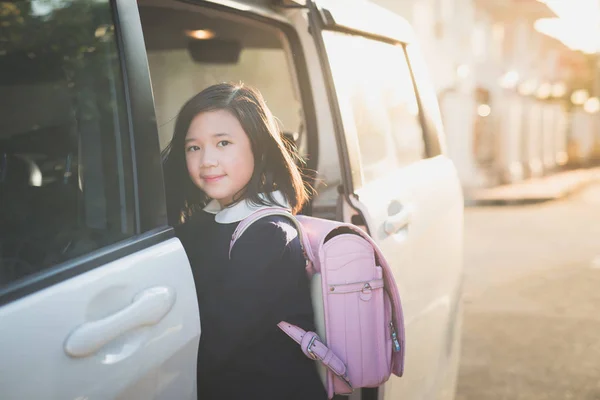 एशियाई लड़की में छात्र वर्दी जा रहा है को स्कूल द्वारा कार — स्टॉक फ़ोटो, इमेज