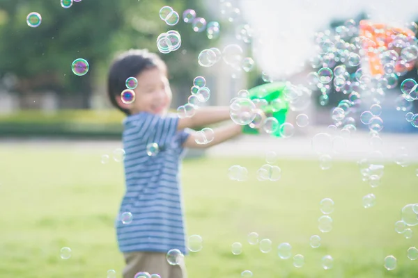 Asiatico bambino shooting bolle da bolla pistola — Foto Stock