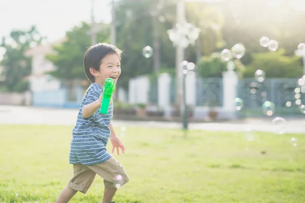 Ázsiai gyermek forgatás buborékok buborék fegyvert — Stock Fotó