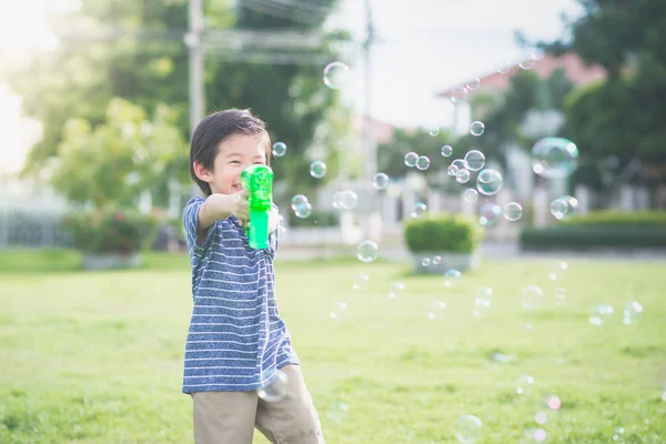 Ásia criança tiro bolhas a partir de bolha arma — Fotografia de Stock