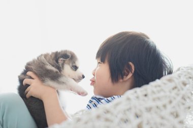 Siberian dış yapraklar köpekle oynayan sevimli Asya çocuk
