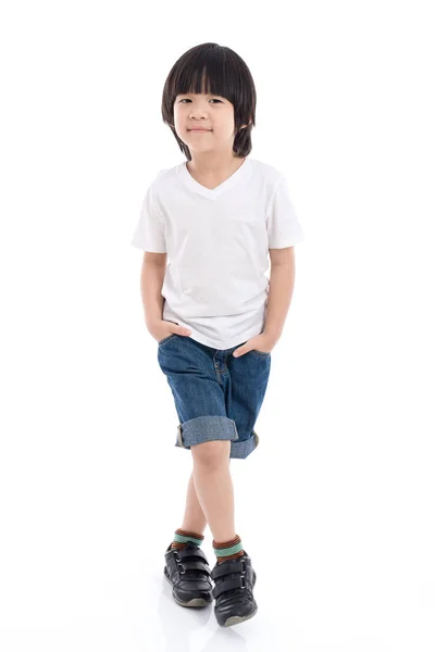 Ребенок в белой футболке и джинсах стоя на белом фоне — стоковое фото
