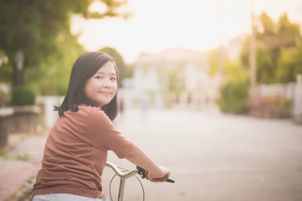 Asiatisk tjej rider cykel i solljus — Stockfoto