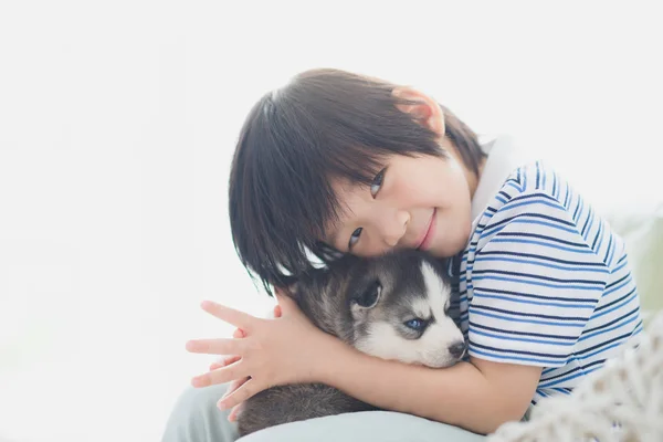 Carino asiatico bambino giocare con siberiano husky cucciolo — Foto Stock