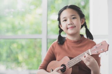 Güzel Asyalı kız oyun ukulele 