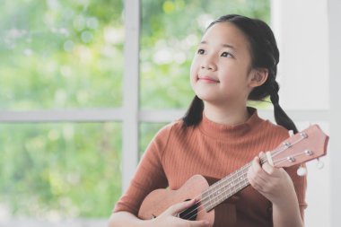 Güzel Asyalı kız oyun ukulele 