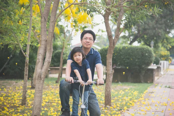 Asijské otec a syn jedoucí na kole — Stock fotografie