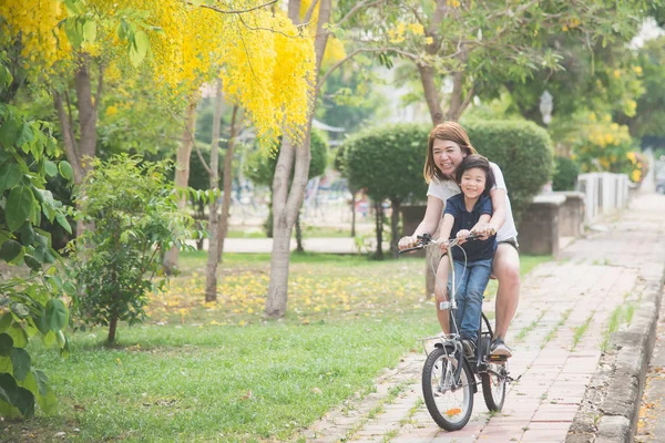 Азиатская мать и сын на велосипеде — стоковое фото