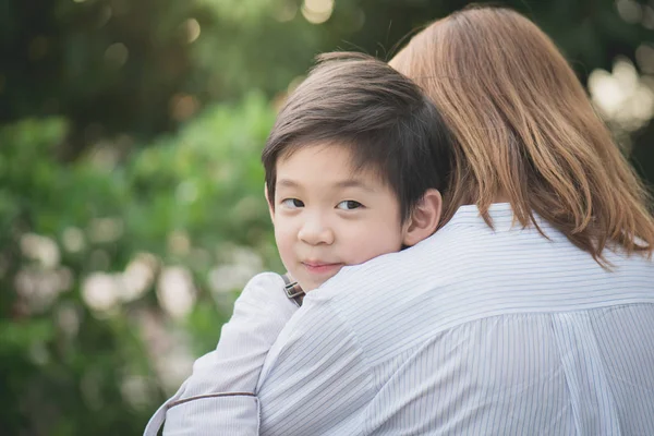 Asian mother hugging with her son in the park — Stock Photo, Image