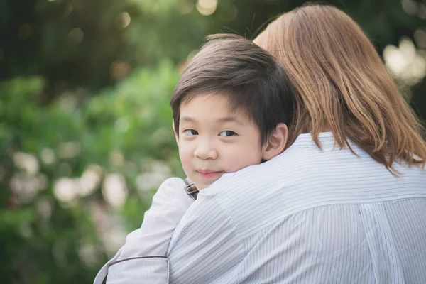 एशियाई माँ पार्क में अपने बेटे के साथ hugging — स्टॉक फ़ोटो, इमेज