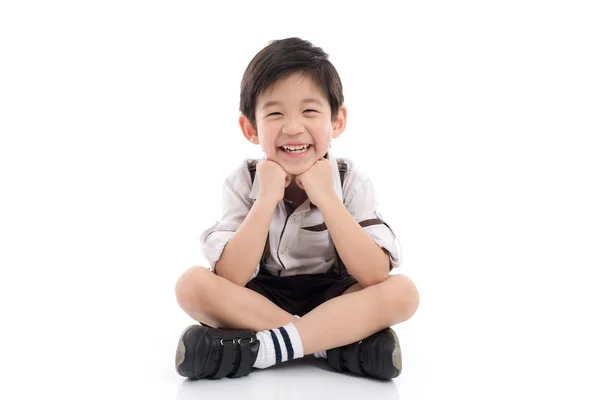 Счастливый азиатский мальчик сидит на белом фоне — стоковое фото