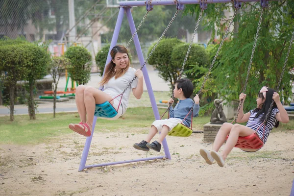 Asian family swinging — Stock Photo, Image