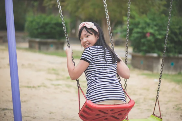 Asiático chica balanceo en el patio de recreo — Foto de Stock