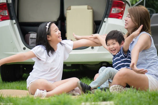 Asijské rodina sedí v parku — Stock fotografie