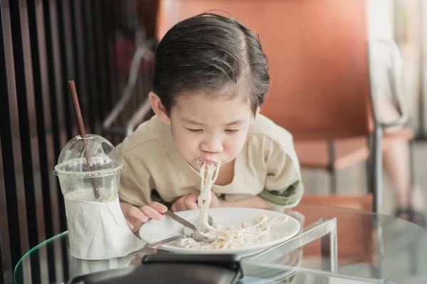 Cute Asian chid eating Spaghetti Carbonara — Stock Photo, Image