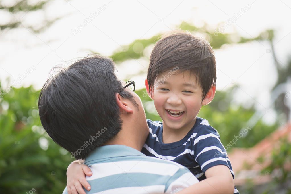 father holding his son in the park