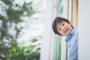 Açık pencereden şirin Asyalı çocuk portresi
