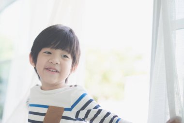 Açık pencereden şirin Asyalı çocuk portresi
