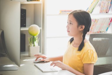 Güzel Asyalı kız masaüstü bilgisayarda çalışarak