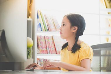 Güzel Asyalı kız masaüstü bilgisayarda çalışarak