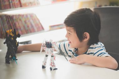 Bangkok, Tayland - 19 Ağustos 2016: Asyalı çocuk Mobile Suit Gundam tek boynuzlu at Hg 1:144 plastik modeli ile