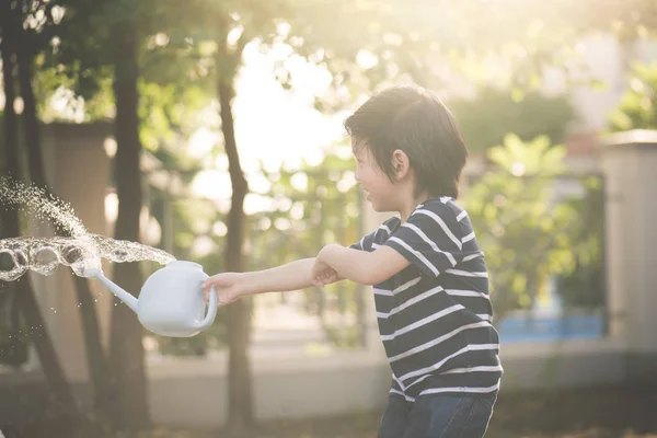 可爱的亚洲孩子夏天在花园里浇水 — 图库照片