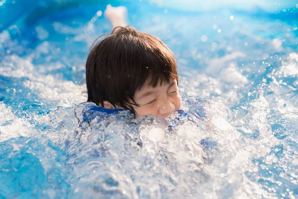 かわいいアジアの少年水泳やプールで遊ぶ — ストック写真