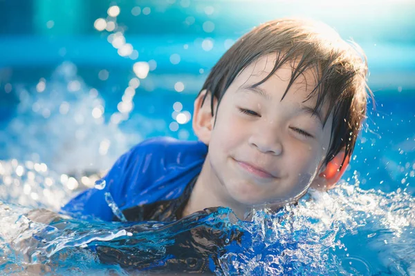 かわいいアジアの少年水泳やプールで遊ぶ — ストック写真