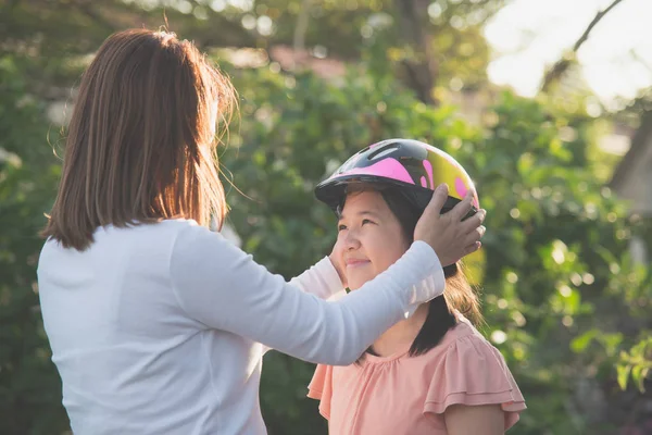 Asya Anne Kızına Bir Bisiklet Kask Takıyor — Stok fotoğraf