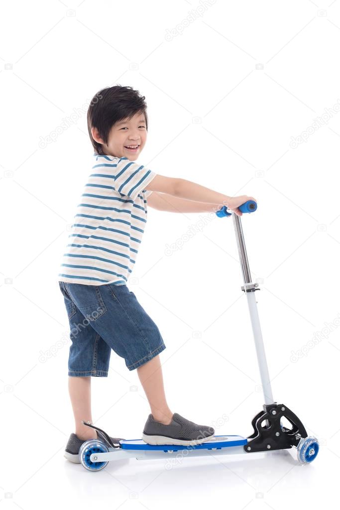 Cute Asian boy riding a scooter on white background isolated