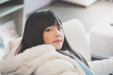 Beyaz koltukta oturan beyaz kış giysileri güzel Asya