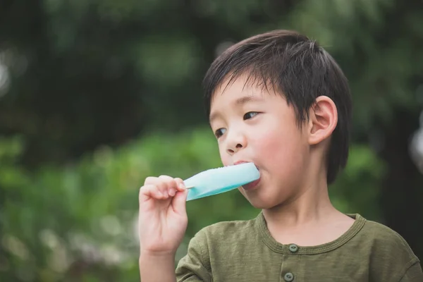 可爱的亚洲孩子在户外吃蓝色冰激淋 — 图库照片