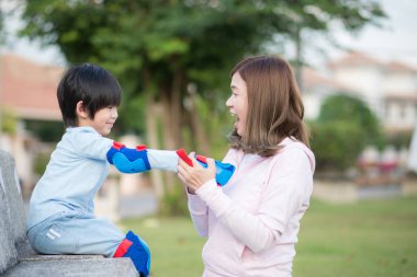 Asya anne oğlu el koruyucular birlikte parkta vaktinizi üzerinde koyarak Yardım
