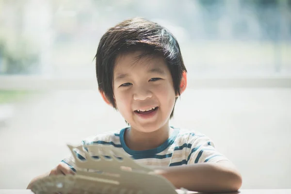 Asiático criança constrói um brinquedo de madeira — Fotografia de Stock