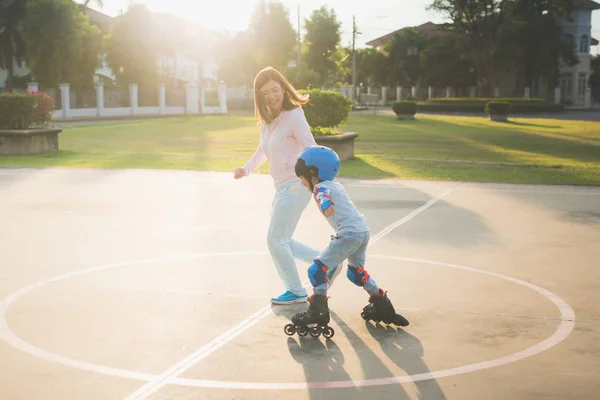 公園でローラー スケートを再生する彼女の息子を助けるアジアの母 — ストック写真