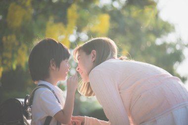 Asyalı çocuk annesi, okul için bir şeyler fısıldıyor