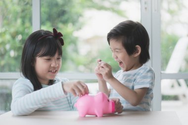 Yazı tura bir kumbara koyarak şirin Asyalı çocuk