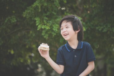 Ahşap maket araba parkında oynayan sevimli Asya çocuk