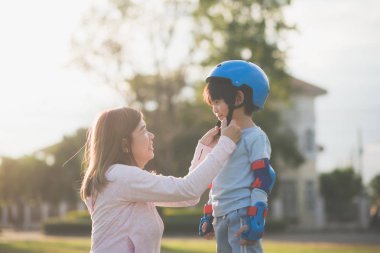 Asya anne oğluna yardım mavi kask zevk zamanında birlikte parkta giyer