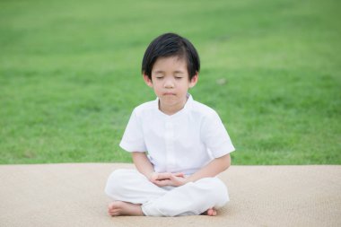 Asyalı çocuk meditasyon Lotus bulunduğu beyaz elbise