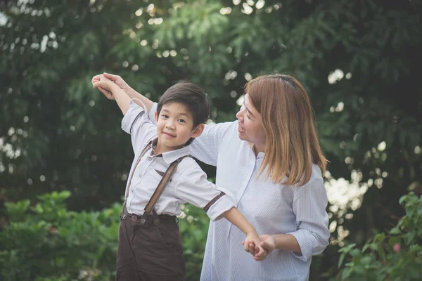 かわいいアジアの子と遊ぶ母パイロット公園屋外での アビエイター 一緒に — ストック写真