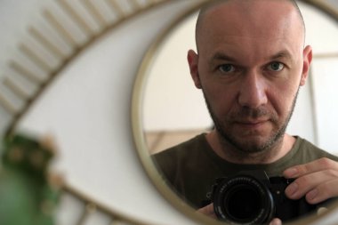 Aynaya bakan kel adam kendini vuruyor. Selfie adamı.