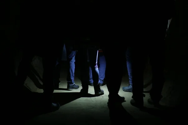 Yeraltı karanlığında gizli bir grup ayak buluşması, bir fener tarafından vurgulanan gizemli bir takipçi, gece zindanda gizli bir toplantı.