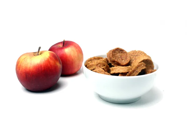 Deux pommes rouges et un bol de bonbons aux fruits isolés sur fond blanc — Photo