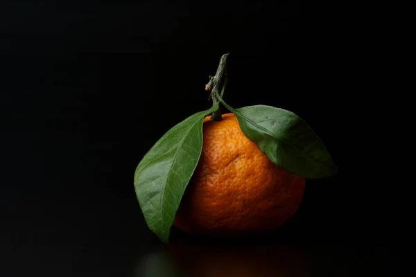 Tangerine with green leaves isolated on black background. Horizontal image — Stock Photo, Image