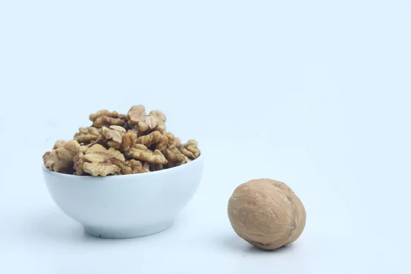 A bowl of peeled walnut and whole walnut isolated on white background — Stock Photo, Image