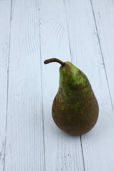 Poire verte isolée sur fond en bois blanc. Image verticale — Photo