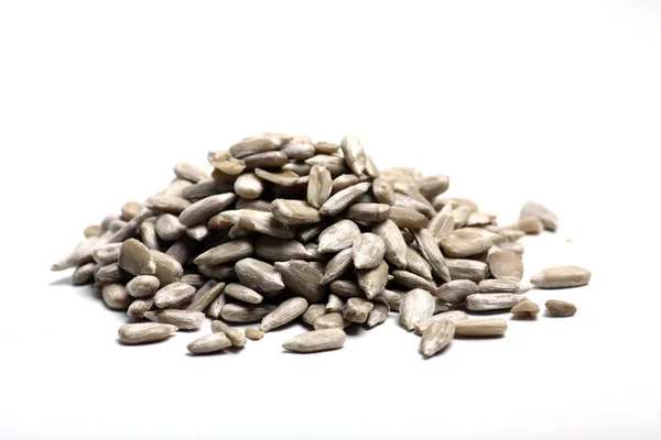Una pila di semi di girasole isolati su fondo bianco posa piatta. Immagine orizzontale — Foto Stock