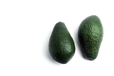 Beyaz arka planda iki avokado izole edilmiş. Yatay görüntü. Düz yatıyordu