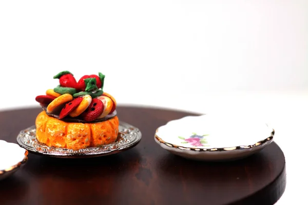 doll house interior - a plate of sliced fruits and two plates on the table